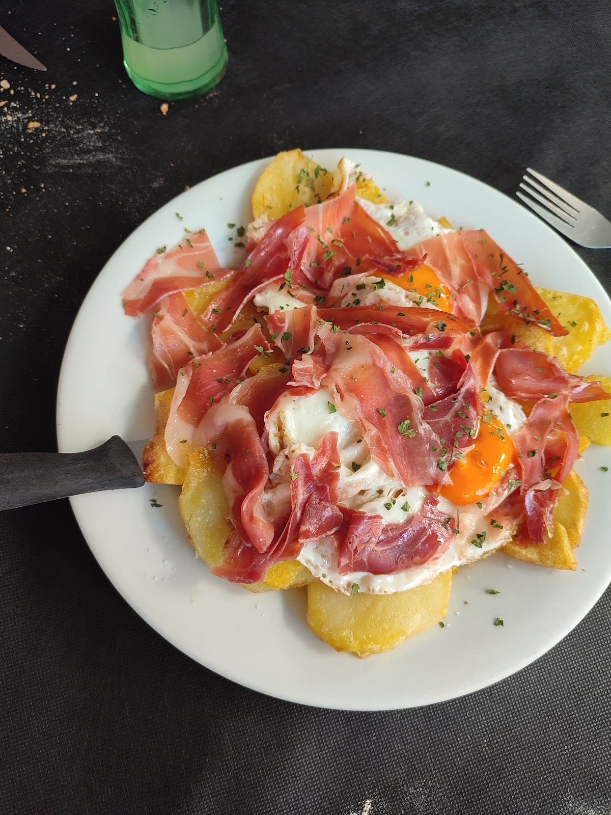 Plato de patatas con jamón y huevo frito